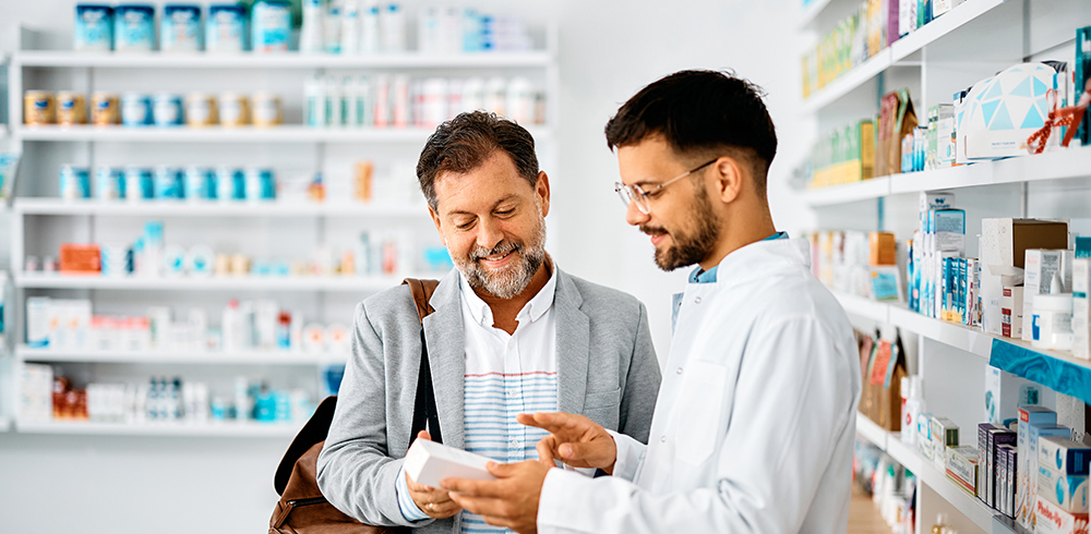 A pharmacist talking to a man about medication