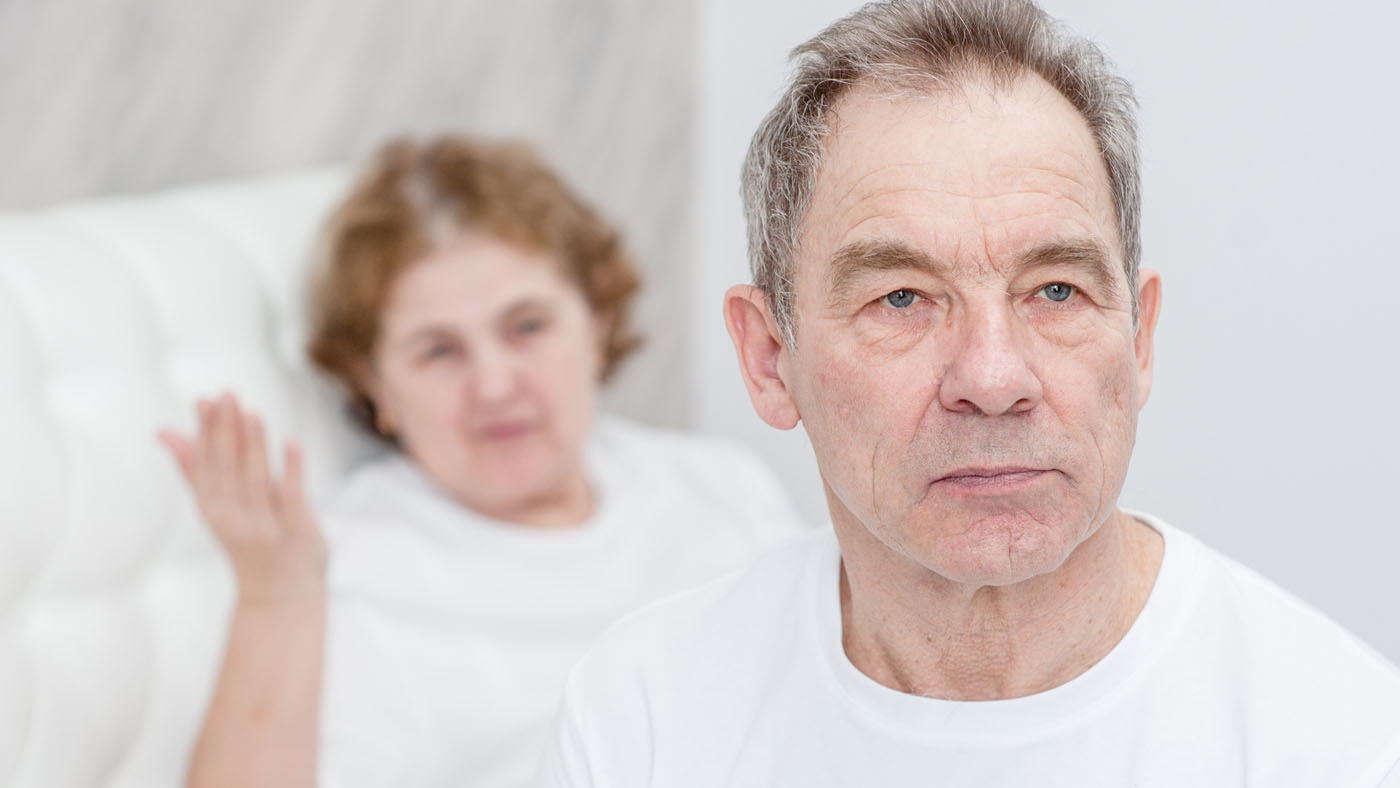 Serious man with woman gesturing, indicating communication tension.